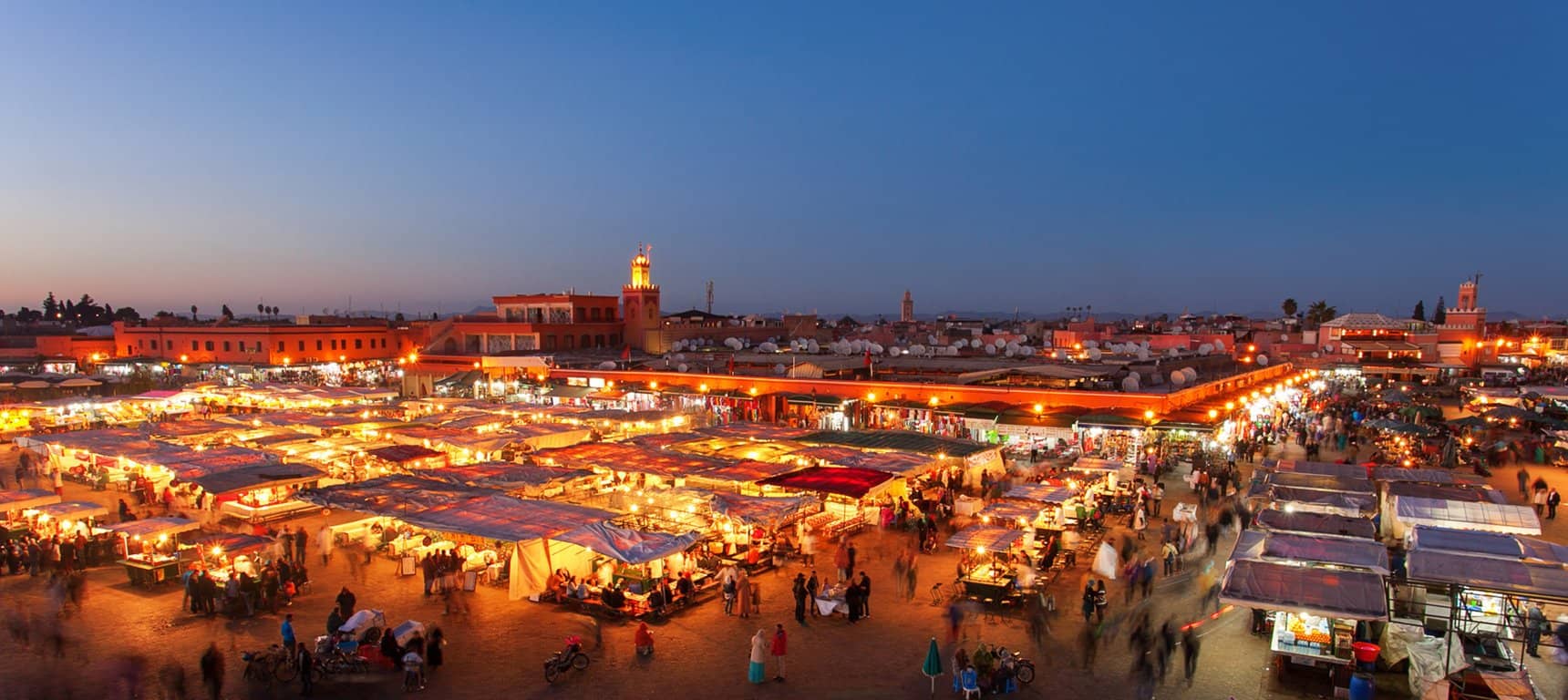 View of Marrakech square bathed in twilight's red glow, capturing the vibrant evening atmosphere.